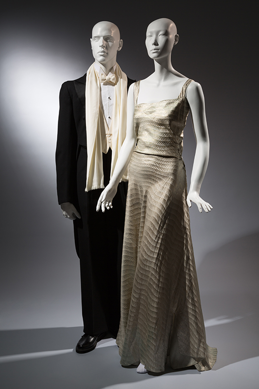 Left: Wood Carlson Co. tailcoat with scarf, Black wool, 1935, New York, gift of Kay Kerr Uebel Right: Evening dress, silk and metallic twill, circa 1935, possibly New York, gift of Mrs. Jessie L. Hills