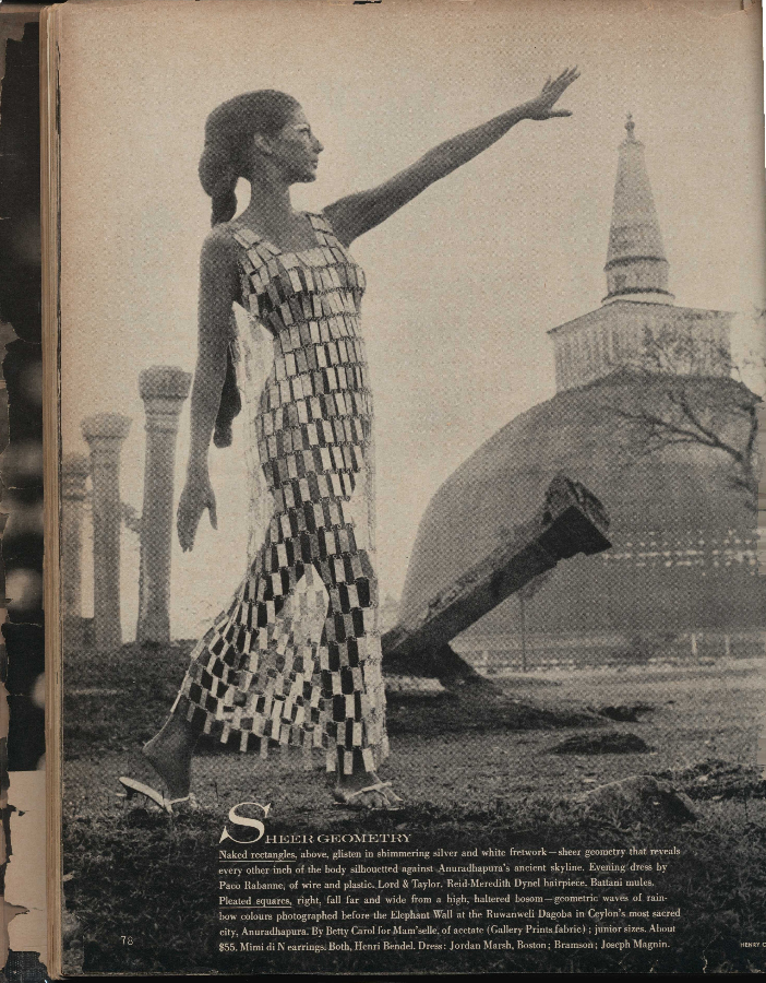 Ankle-length, sleeveless, shift-silhouette wedding dress made of white, pearlescent, and silver glitter plastic rectangles attached with metal loops in “chainmail” style.