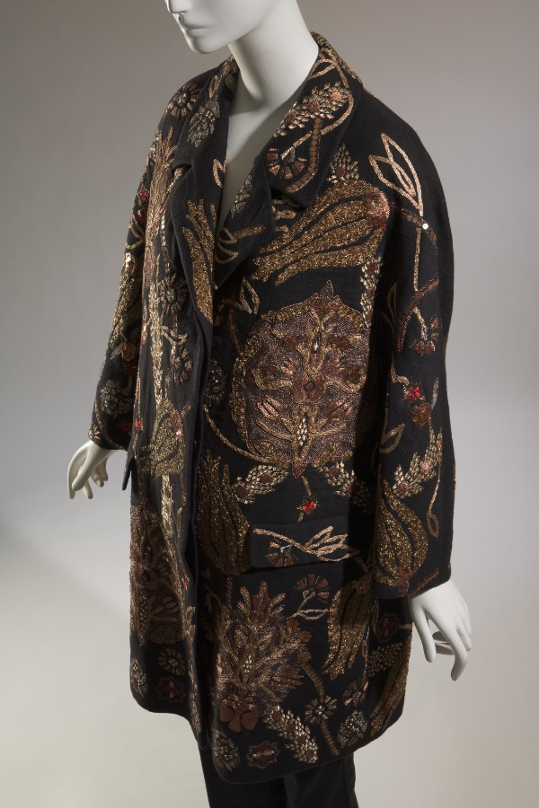 Knee length, loose fit black linen evening coat with large floral and vine embroidery made of metallic gold thread, metallic sequins, metal beading.