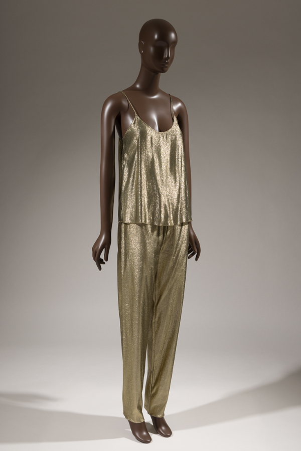 Evening set in synthetic gold lamé fabric with matching spaghetti-strap camisole top and tapered-leg pants.