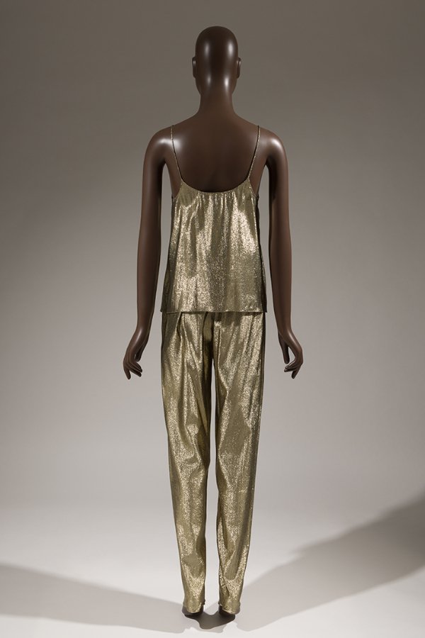 Back of evening set in synthetic gold lamé fabric with matching spaghetti-strap camisole top and tapered-leg pants.