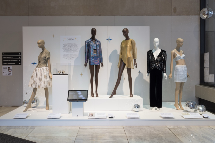 zoomed-out view of "Fabric" section of in-person All that Glitters exhibition, featuring five mannequins, one pair shoes