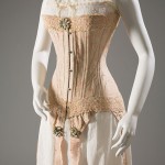 Early twentieth-century corsets rested low on the bosom, and extended over the hips. When laced, the so-called “straight-front” corset provided an “S curve” that pushed the breasts forward, pressed in the stomach, and arched the back. Although visually alluring (and pioneered by female corsetières), this corset style was highly constricting. Corset: Floral brocaded silk, silk ribbon, elastic, circa 1905, England, 98.37.1, museum purchase Chemise (slip): White cotton, silk ribbon, circa 1905, USA, 2012.53.2, gift of Leigh Bantivoglio