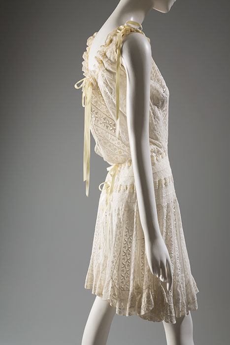 Undergarments became increasingly streamlined during the late 19th century. Combinations, which joined a camisole and drawers into a single garment, were especially prevalent. The desire to eliminate layers of undergarments corresponded to the slimmer dress silhouette of the Edwardian era. Cotton eyelet lace, silk ribbon, circa 1900, USA, U.131, origin unknown