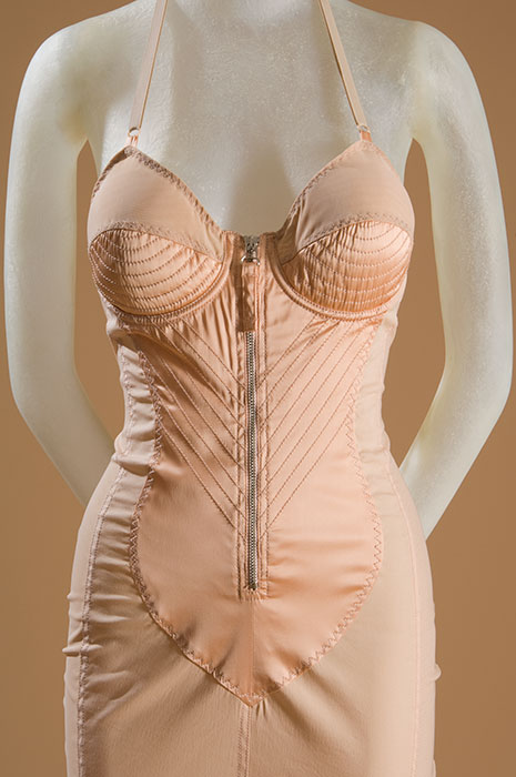 Jean Paul Gaultier’s interest in lingerie can be traced back to his childhood, when he discovered his grandmother’s corset. “From that moment I became fascinated by the idea of transforming one’s body with clothes,” he recalled. Gaultier’s body-conscious dresses, inspired by girdles and corsets, helped to ignite a trend for underwear-as-outerwear during the 1980s. Peach cotton/nylon blend, peach satin, circa 1987, France, 98.98.1 ,museum purchase