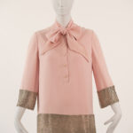 pink dress with pink bow at neck and pink buttons down center. the dress features silver beads trim on arms and bottom of dress