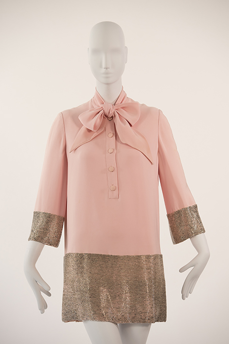 pink dress with pink bow at neck and pink buttons down center. the dress features silver beads trim on arms and bottom of dress