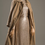 brown cashmere coat draped over gold sequined dress