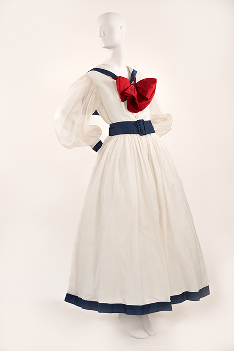 white sailor dress with blue trim, blue belt and big red bow and center of chest