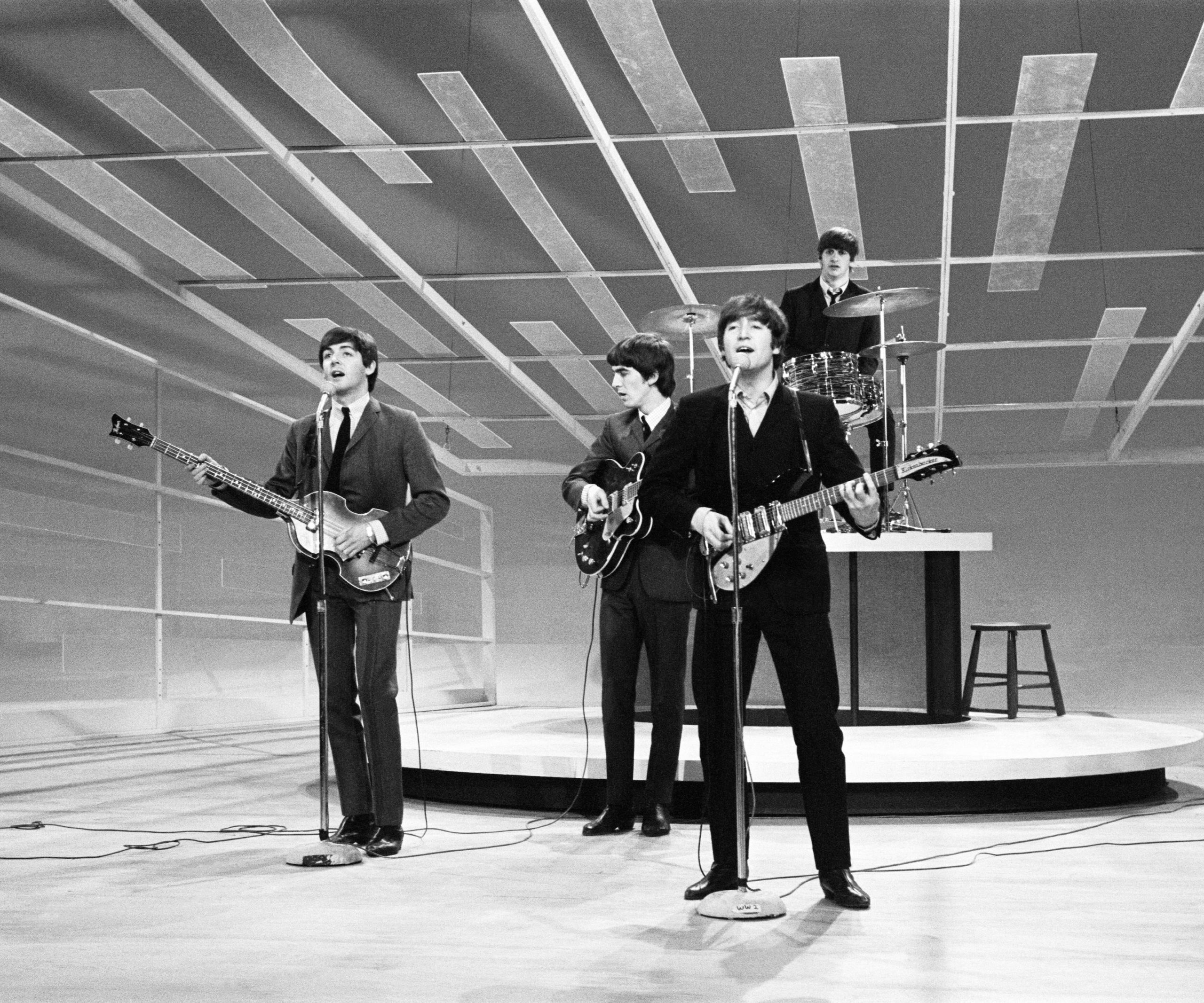 The Beatles stand on stage as they rehearse for their appearance on the Ed Sullivan show 1964